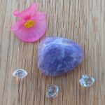 Purple tumbled gemstone with pink flower and clear crystals