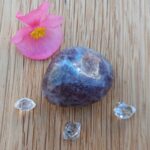 Polished purple stone with crystals and pink flower