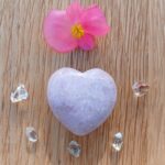 Pink flower and lavender heart crystal on wood