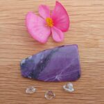Purple polished stone with pink flower and crystals