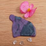 Purple gua sha tool with flower and crystals
