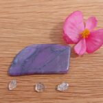 Purple polished stone, pink flower and clear crystals