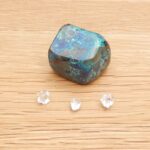 Blue-green polished stone with three small clear gems