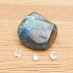 Iridescent polished stone with three clear crystals