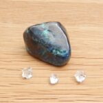 Polished blue-green stone with three clear crystals