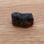 Rough dark brown stone on wooden surface