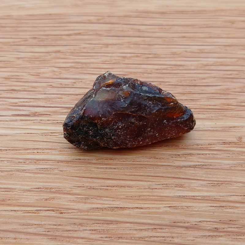 Rough amber stone on wooden surface