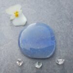 Polished blue stone with flower and crystals