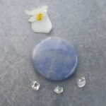 Blue polished stone with flower and crystals