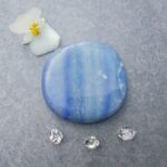 Blue polished stone with flower and crystals