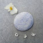Blue polished stone with flower and clear crystals
