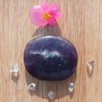 Polished purple stone with flower and clear crystals