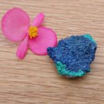 Pink flower beside blue and green mineral specimen