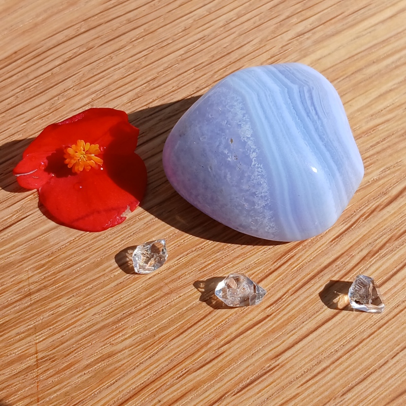 Blue banded stone, red flower and clear crystals