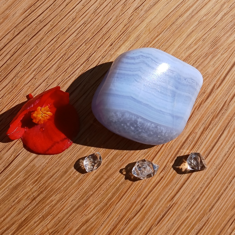 Blue banded stone, red flower and clear crystals