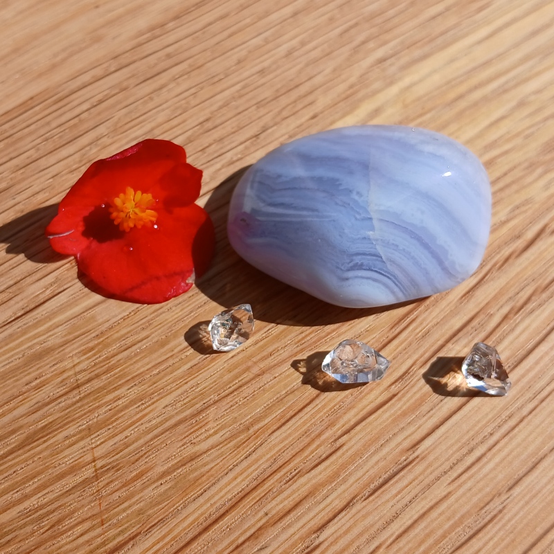 Red flower, blue stone and clear crystals on wood