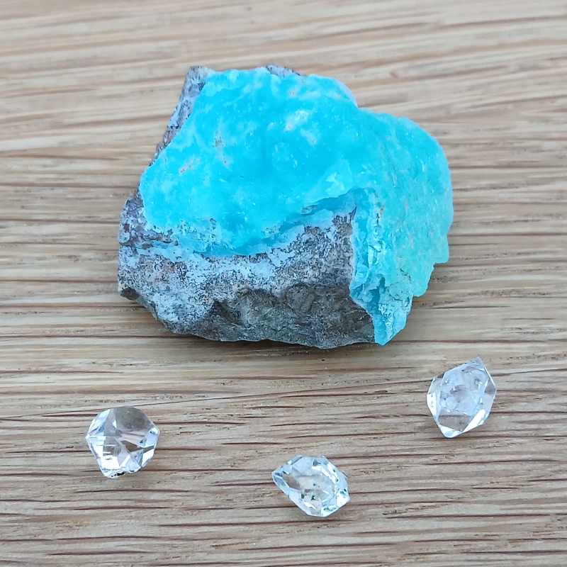 Bright blue mineral specimen with three clear faceted crystals