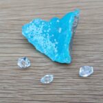 Bright blue mineral specimen with three clear faceted crystals