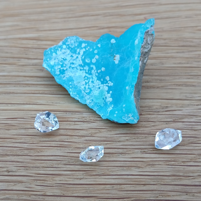 Bright blue mineral specimen with three clear faceted crystals