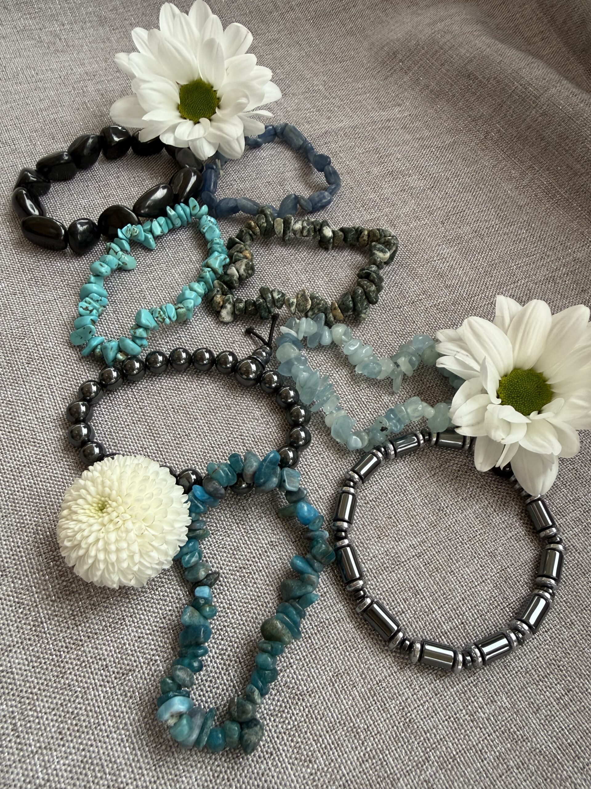 Gemstone bead necklaces arranged with white flowers