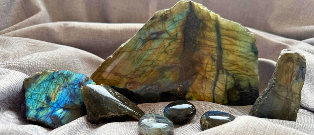 Iridescent labradorite stones displayed on soft grey fabric