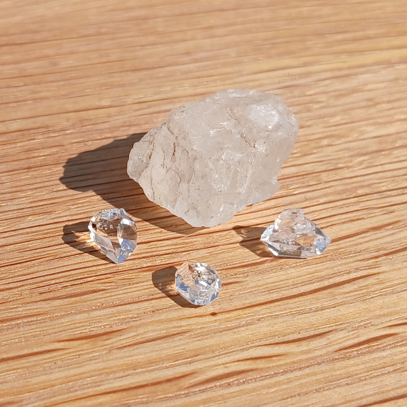 Clear quartz crystals on sunlit wooden surface