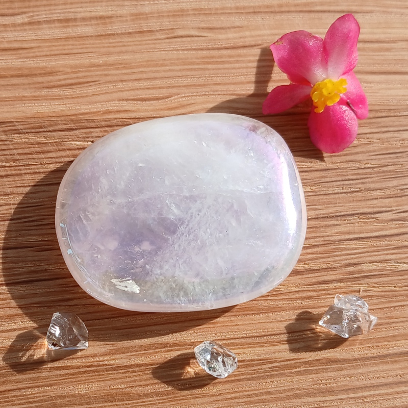 Polished pale amethyst with flower and crystal chips on wood