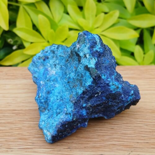 Vivid blue mineral specimen on wooden surface