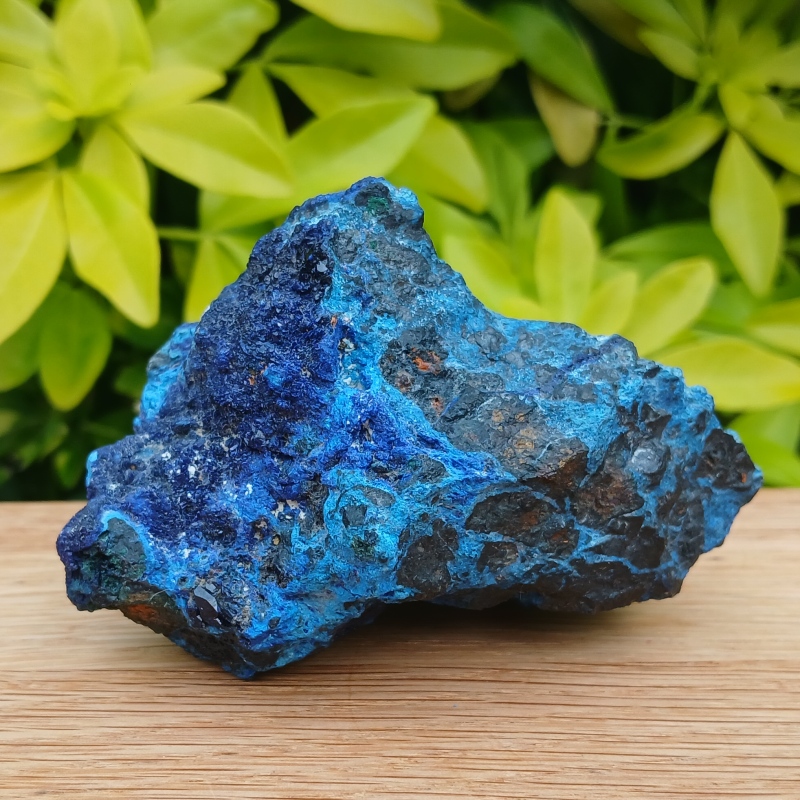 Vivid blue mineral rock specimen on wooden surface
