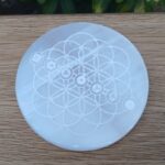 Engraved circular selenite plate with sacred geometry design